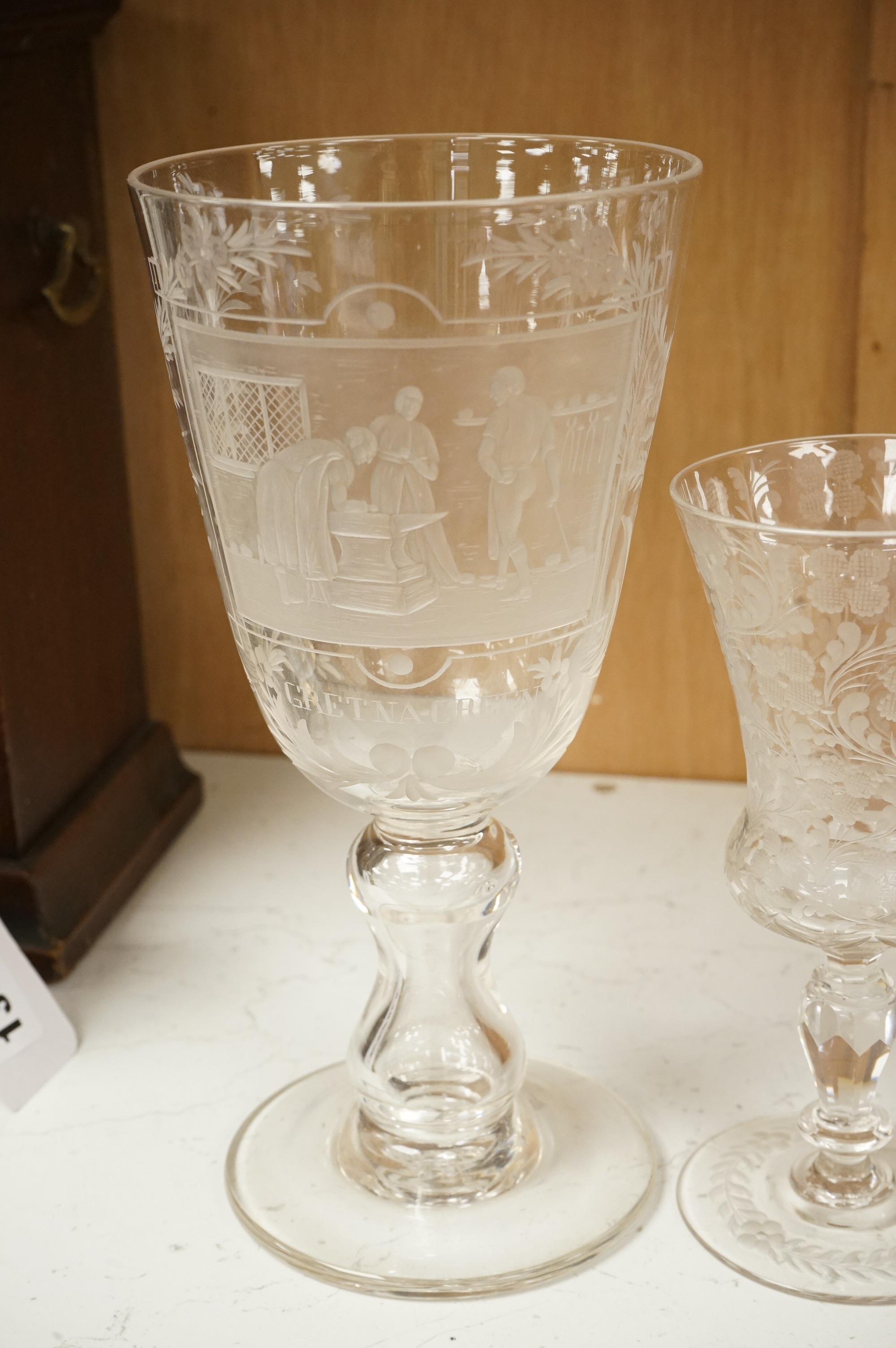 An 18th century sweetmeat glass, a 19th century large wheel engraved ‘Gretna Green’ goblet and a smaller floral engraved glass, tallest 23cm